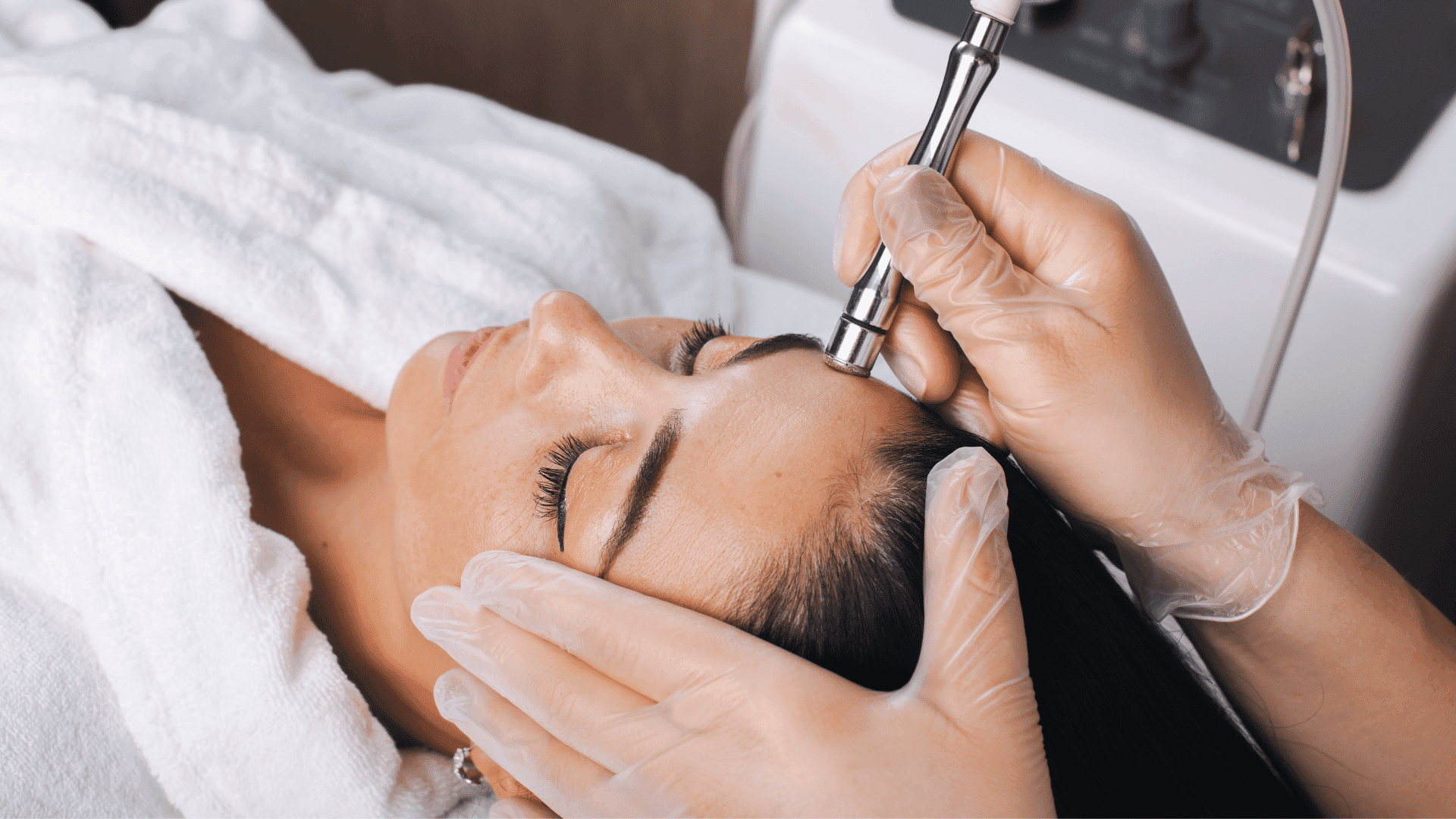 Person receiving a facial microdermabrasion treatment at a spa.